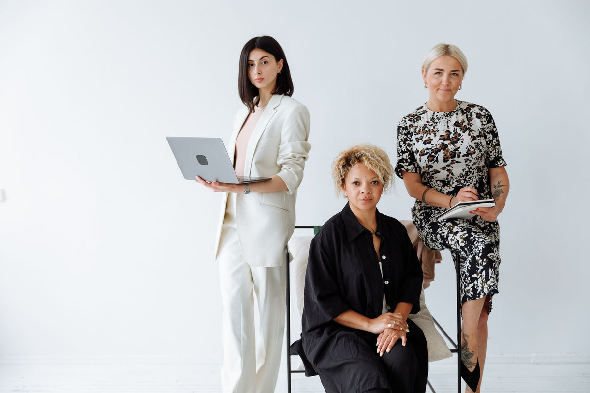 A diverse group of professional women posing confidently in a modern office setting.